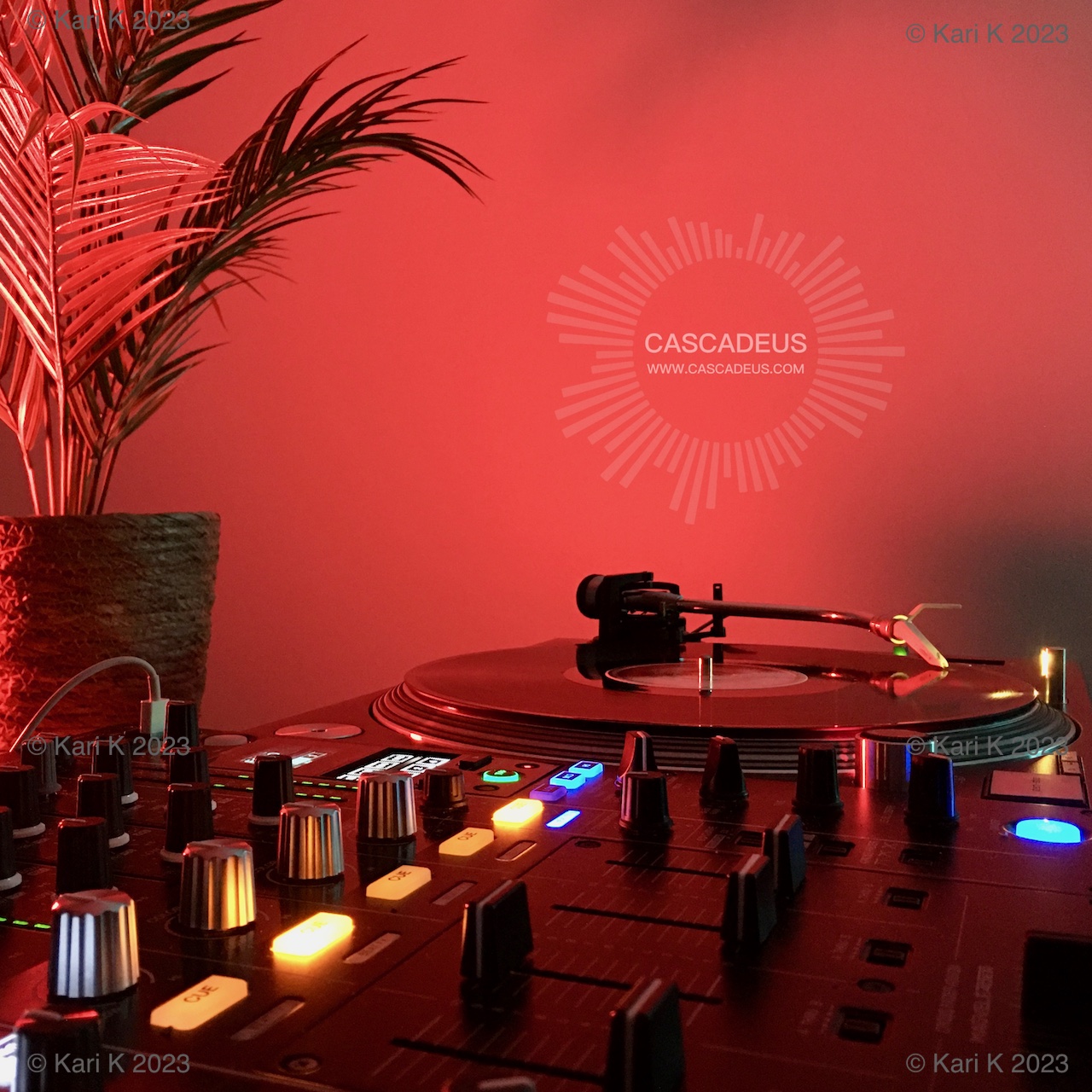 Cascadeus Remixes kuvake. Valokuva tunnelmallisesti punasävyisesti valaistusta tiskijukan työpisteestä.